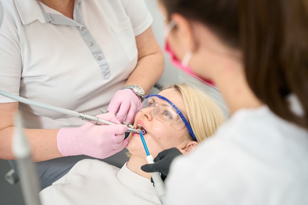 Adult lady sitting in a dental chair at two doctors