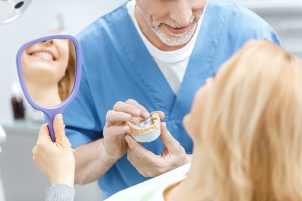 dentist showing jaws model to patient in dental clinic