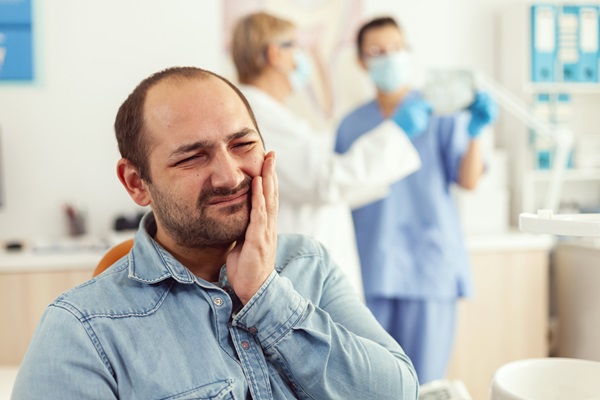 Man patient complaining about teeth pain while waiting for stomatologist doctors