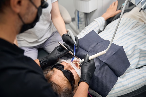 Woman is getting her teeth treated in a dental clinic