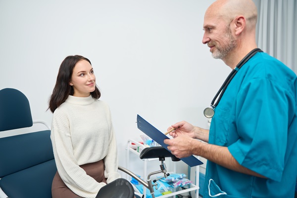 Woman is sitting on gynecological chair next to doctor