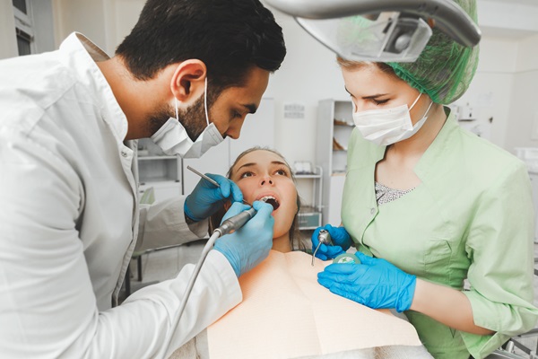 Young talented dentist and his assistant nurse at work